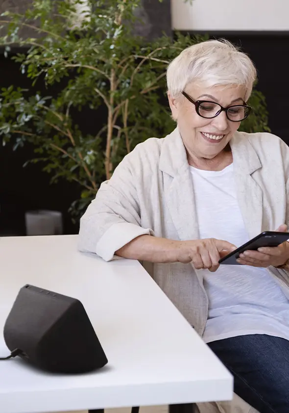 Una signora anziana sorridente utilizza un tablet